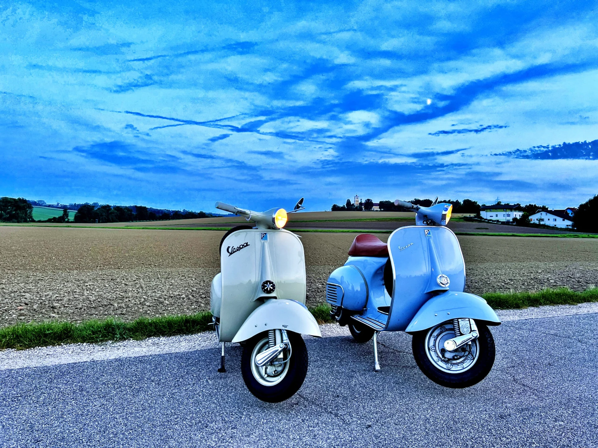 Zwei klassische Vespas auf einer Landstraße